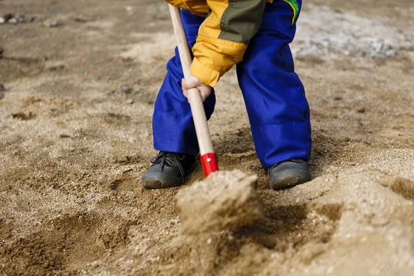 Child play with sand and red shovel — Stock Photo, Image