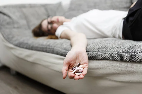 Mujer muerta se acuesta en el sofá después de comer drogas o pastillas — Foto de Stock