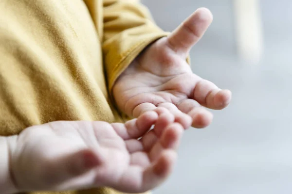 Petites mains d'enfant - enfant, chemise jaune — Photo