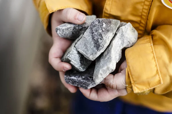 Piedras grises en manos de niño pequeño lindo Fotos De Stock