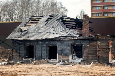 Merkezinde yanmış eski bir ev olan modern bir şehir.