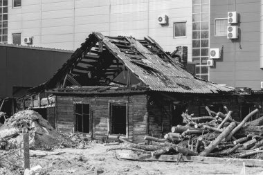 Merkezinde yanmış eski bir ev olan modern bir şehir.