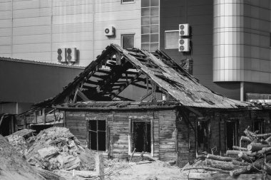 Merkezinde yanmış eski bir ev olan modern bir şehir.