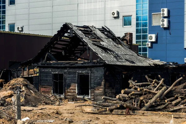 A modern city with a burnt out old house in the center — Stock Photo, Image