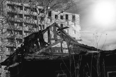 Merkezinde yanmış eski bir ev olan modern bir şehir.