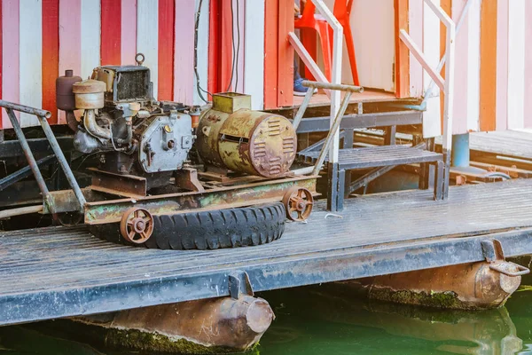 El viejo generador de electricidad para casa balsa de madera flotante mediante el uso de barco de remolque . — Foto de Stock