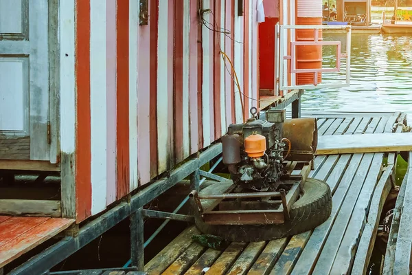 O gerador de eletricidade velho para flutuar casa de jangada de madeira usando barco de reboque . — Fotografia de Stock
