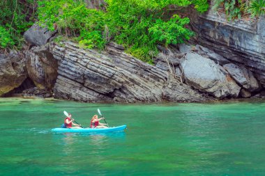 Ang Thong Deniz Parkı, Samui, Tayland - 13 Ekim 2019: Idyllic turkuaz okyanusunda kayak yapan turistler, Ang Thong Ulusal Deniz Parkı 'ndaki yeşil orman ağaçları ve kireç taşı dağlarıyla adanın yakınını keşfetmek için.