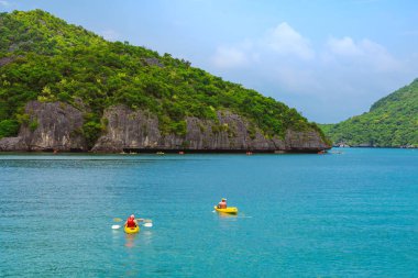 Ang Thong Deniz Parkı, Samui, Tayland - 13 Ekim 2019: Idyllic turkuaz okyanusunda kayak yapan turistler, Ang Thong Ulusal Deniz Parkı 'ndaki yeşil orman ağaçları ve kireç taşı dağlarıyla adanın yakınını keşfetmek için.