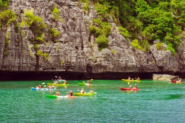 Ang Thong Deniz Parkı, Samui, Tayland - 13 Ekim 2019: Idyllic turkuaz okyanusunda kayak yapan turistler, Ang Thong Ulusal Deniz Parkı 'ndaki yeşil orman ağaçları ve kireç taşı dağlarıyla adanın yakınını keşfetmek için.