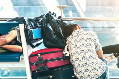 Havaalanı terminalinde yolcu beklerken banklarda kestirirken yorgun düşmüş..