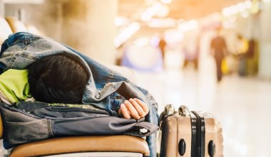 Havaalanı terminalinde yolcu beklerken banklarda kestirirken yorgun düşmüş..