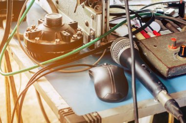 Eski siyah bir yoğunlaştırıcı mikrofon ve ses kontrol masasının üzerine açık hava duyurularında kullanılan karışık bir kablo yerleştirilmiş siyah bir fare..