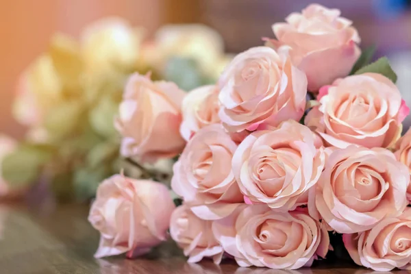 Beau bouquet de roses artificielles roses placé sur la table pour décorer le café . — Photo