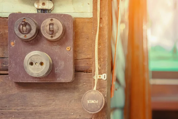 Tahta bir tahtanın üzerinde çok eski bir elektrikli retro düğmeye yakın. Klasik anahtar, Seçici odak — Stok fotoğraf