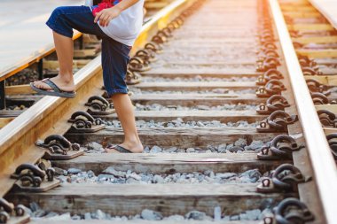Turistler, Kanchanaburi, Tayland 'daki Kwai Köprüsü' nü ziyaret ederken tren rayları boyunca yürüyorlar..