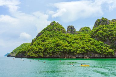 Ang Thong Deniz Parkı, Samui, Tayland - 13 Ekim 2019: Idyllic turkuaz okyanusunda kayak yapan turistler, Ang Thong Ulusal Deniz Parkı 'ndaki yeşil orman ağaçları ve kireç taşı dağlarıyla adanın yakınını keşfetmek için.