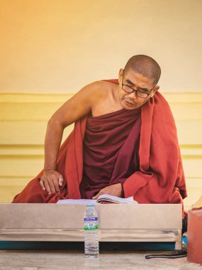 PAGAN-Myanmar, 21 Ocak 2019: Tanımlanamayan keşiş Shwezigon Pagoda 'da Budist yazıtlarıyla birlikte Pagan, Myanmar' da 21 Ocak 2019 'da meditasyon yapar ve dua eder..