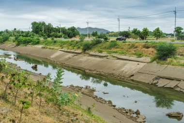 Beton duvardaki sulama kanalları su rezervuarından Tayland 'ın yağmur mevsiminde kuruyan çiftçinin tarım alanına su gönderir. Tarım sektöründe çevre felaketi