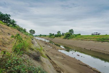 Beton duvardaki sulama kanalları su rezervuarından Tayland 'ın yağmur mevsiminde kuruyan çiftçinin tarım alanına su gönderir. Tarım sektöründe çevre felaketi
