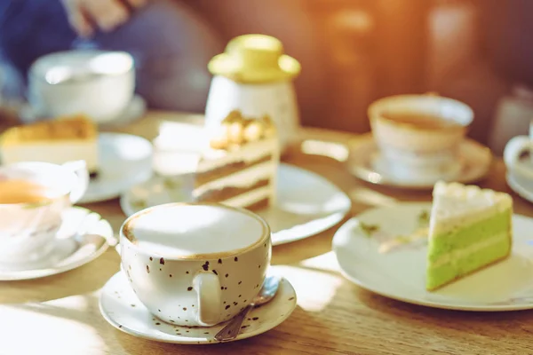 Felicidad amigos femeninos reunirse y beber té o café con pasteles juntos en la cafetería por la tarde. Concepto de personas, ocio y comunicación. Enfoque selectivo. — Foto de Stock