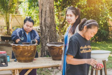 LAMPHUN THAILAND - 12 ARALIK: tanımlanamayan Taylandlı kadın turistler, Tayland 'ın Lamphun kentindeki Karen köyünde 12 Aralık 2019 tarihinde kravat boyası yapmayı öğreniyorlar.