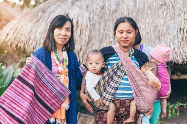 Lamphun Tayland - 8 Aralık: Tanımlanamayan kadın turist Karen ailesiyle 8 Aralık 2019 'da Tayland' ın Lamphun kentindeki Karen köyünde fotoğraf çektirdi.