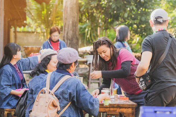 TAILANDIA DE LÁMFONO - 12 DE DICIEMBRE: Turistas tailandesas no identificadas aprenden a hacer un collar de una bola de hilado el 12 de diciembre de 2019 en la aldea Karen en Lamphun, Tailandia — Foto de Stock