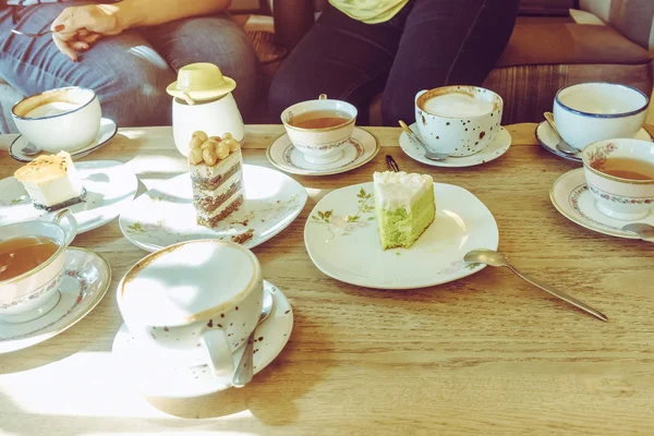 행복 한 여성 친구들은 오후에 카페에서 케이크와 함께 모여서 차나 커피를 마십니다. 사람, 여가 및 의사소통의 개념. 선택적 초점. — 스톡 사진