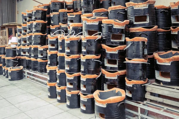 Muchas antiguas estufas de carbón dispuestas en una fila ordenada para la venta a los clientes asiáticos en la tienda de comestibles . —  Fotos de Stock