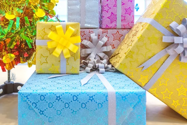 Красивые различные подарочные коробки или подарки разного размера и формы с лентой на столе в партии — стоковое фото