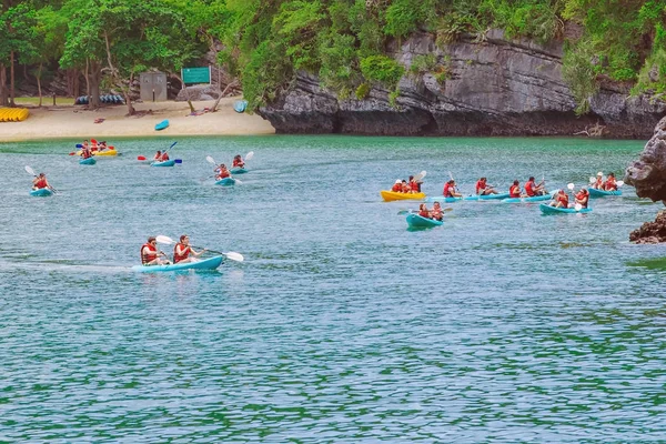 ANG THONG MARINE PARK, SAMUI, THAILAND - OCTOBER 13,2019 : Tourists kayaking in blue Idyllic turquoise ocean to explore near the island with lush green jungle trees and lime stone mountains at Ang Thong National Marine Park, Thailand. — Stock Photo, Image