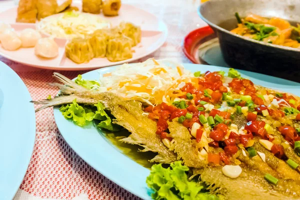 Pescado frito y rematado con salsa de chile junto con otros tipos de alimentos colocados en la mesa de la cena en las fiestas. Enfoque selectivo . — Foto de Stock