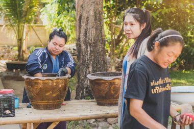 LAMPHUN THAILAND - 12 ARALIK: tanımlanamayan Taylandlı kadın turistler, Tayland 'ın Lamphun kentindeki Karen köyünde 12 Aralık 2019 tarihinde kravat boyası yapmayı öğreniyorlar.