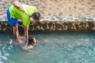 KANCHANABURI, THAILAND - 1 Ocak 2020 'de Kanchanaburi, Tayland' da kimliği belirlenemeyen Asyalı turistler cesedi sıcak maden suyuna batırıp sağlık için Hindad Hotspring 'te yıkandılar..