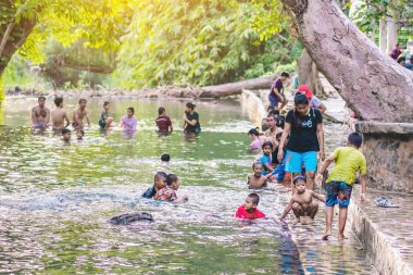 KANCHANABURI, THAILAND - 1 Ocak 2020 'de Kanchanaburi, Tayland' da kimliği belirlenemeyen Asyalı turistler cesedi sıcak maden suyuna batırıp sağlık için Hindad Hotspring 'te yıkandılar..