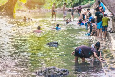 KANCHANABURI, THAILAND - 1 Ocak 2020 'de Kanchanaburi, Tayland' da kimliği belirlenemeyen Asyalı turistler cesedi sıcak maden suyuna batırıp sağlık için Hindad Hotspring 'te yıkandılar..