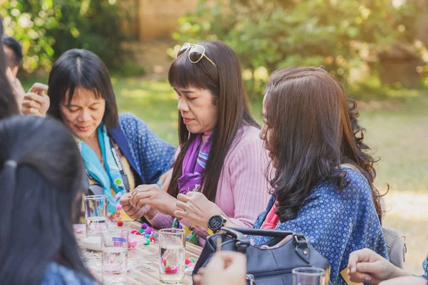 TAILANDIA DE LÁMFONO - 12 DE DICIEMBRE: Turistas tailandesas no identificadas aprenden a hacer un collar de una bola de hilado el 12 de diciembre de 2019 en la aldea Karen en Lamphun, Tailandia — Foto de Stock