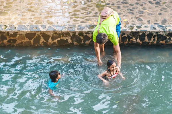 KANCHANABURI, THAILAND - 1 Ocak 2020 'de Kanchanaburi, Tayland' da kimliği belirlenemeyen Asyalı turistler cesedi sıcak maden suyuna batırıp sağlık için Hindad Hotspring 'te yıkandılar..