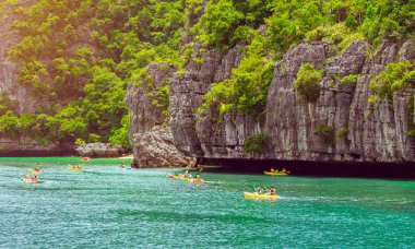 Ang Thong Deniz Parkı, Samui, Tayland - 13 Ekim 2019: Idyllic turkuaz okyanusunda kayak yapan turistler, Ang Thong Ulusal Deniz Parkı 'ndaki yeşil orman ağaçları ve kireç taşı dağlarıyla adanın yakınını keşfetmek için.