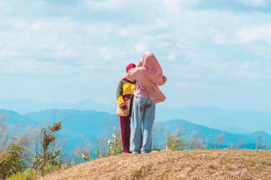 Müslüman kadın tesettüre ve tesettüre bürünmüş ve tesettüre bürünmüş, Fil Tepeleri Manzara Noktası 'nın en güzel manzarasının keyfini çıkarmaktadır..