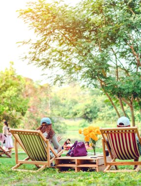 Mutlu çift, yaz tatilinde bahçe sandalyelerinde oturur, parkta dinlenir..