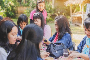 Lamphun Thailand - 12 Aralık - Tayland 'da tanımlanamayan Tayland' lı kadın turist - 12 Aralık - Tanımlanamayan Tayland 'lı kadın turistler, Tayland' ın Lamphun kentindeki Karen köyünde 12 Aralık 2019 tarihli iplik balosundan kolye yapmayı öğrendiler.