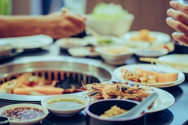 İnsanlar bir restoranda dumansız barbekü ızgara et ızgara. Karideslere seçici odaklanma.