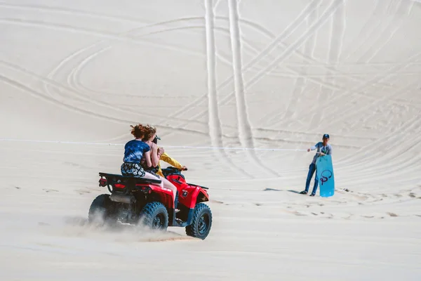 MUI NE-VIETNAM-ABRIL 24, 2019: Los turistas no identificados disfrutan montando la quad bike o los potentes todoterreno todoterreno todoterreno en las dunas de arena blanca el 24 de abril de 2019 en Mui Ne, Vietnam. — Foto de Stock