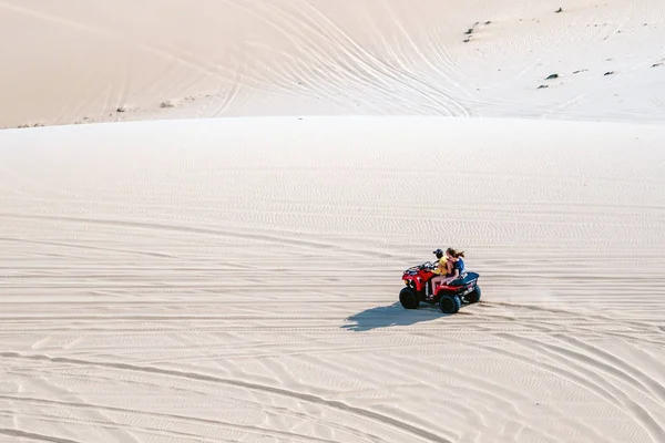 MUI NE-VIETNAM-ABRIL 24, 2019: Los turistas no identificados disfrutan montando la quad bike o los potentes todoterreno todoterreno todoterreno en las dunas de arena blanca el 24 de abril de 2019 en Mui Ne, Vietnam. — Foto de Stock