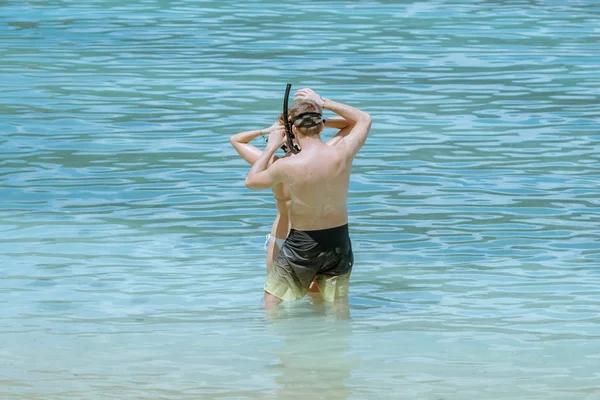 Um cavalheiro ajudou a usar óculos para seu amante antes de mergulhar para ver o belo coral no mar. — Fotografia de Stock