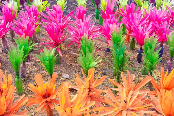 Recycled colorful plastic flowers made from plastic bottles to decorate as flowers in the garden. Plastic bottle recycled.