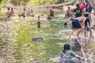 KANCHANABURI, THAILAND - 1 Ocak 2020 'de Kanchanaburi, Tayland' da kimliği belirlenemeyen Asyalı turistler cesedi sıcak maden suyuna batırıp sağlık için Hindad Hotspring 'te yıkandılar..