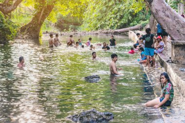 KANCHANABURI, THAILAND - 1 Ocak 2020 'de Kanchanaburi, Tayland' da kimliği belirlenemeyen Asyalı turistler cesedi sıcak maden suyuna batırıp sağlık için Hindad Hotspring 'te yıkandılar..